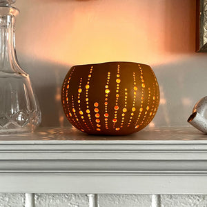 calabash lantern with a intricate design light up by a candle