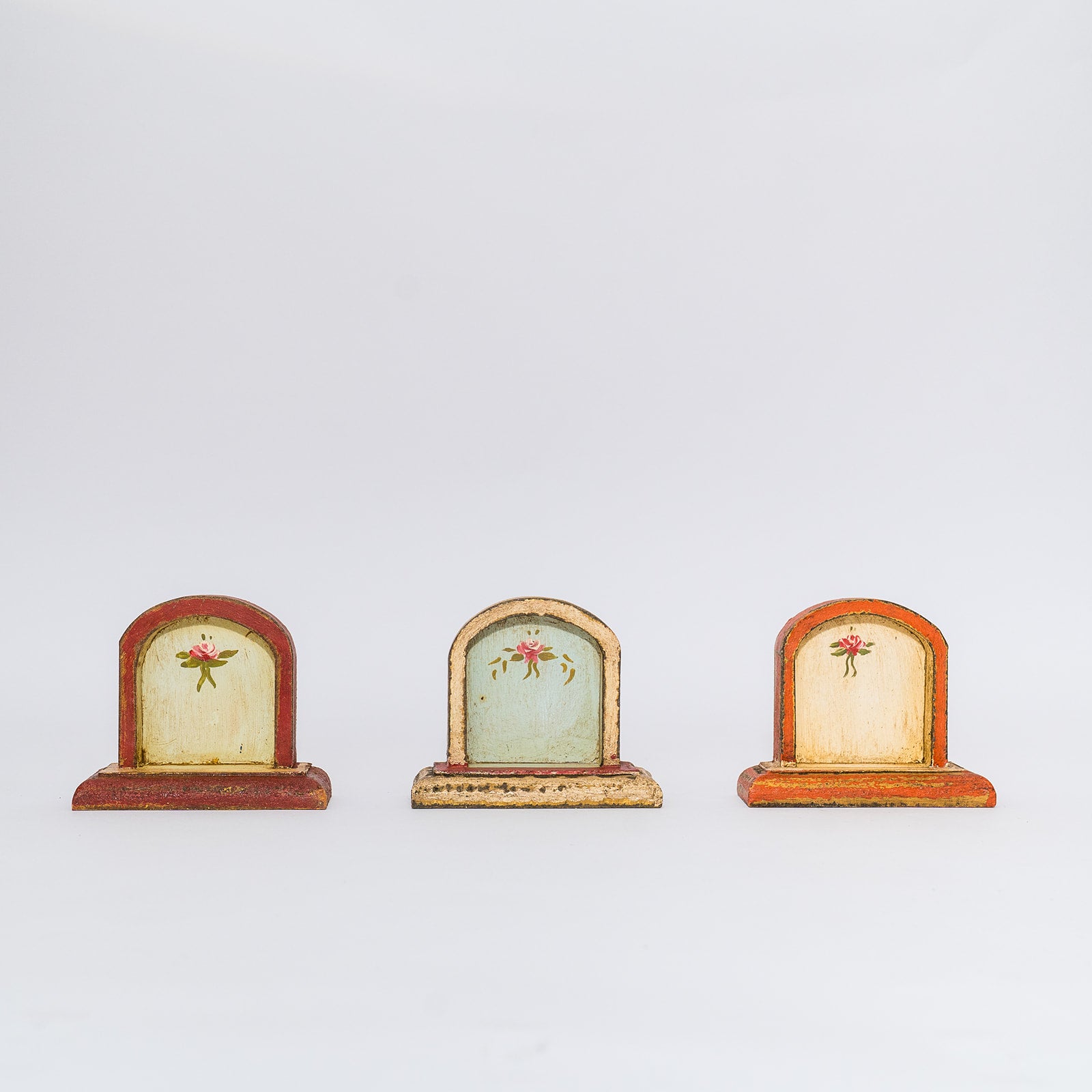 three wooden altars displayed in a row